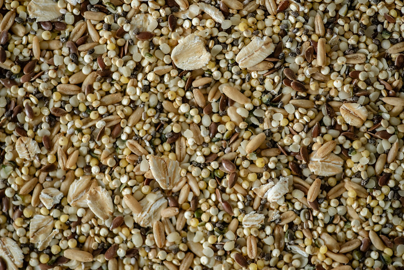 Macro de mélange de millet jaune, graines de lin marron et flocons d'avoine pour psittacidés
